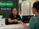 Frontliner assisting a patient at the reception desk of an optometry practice in Protea North, Soweto.